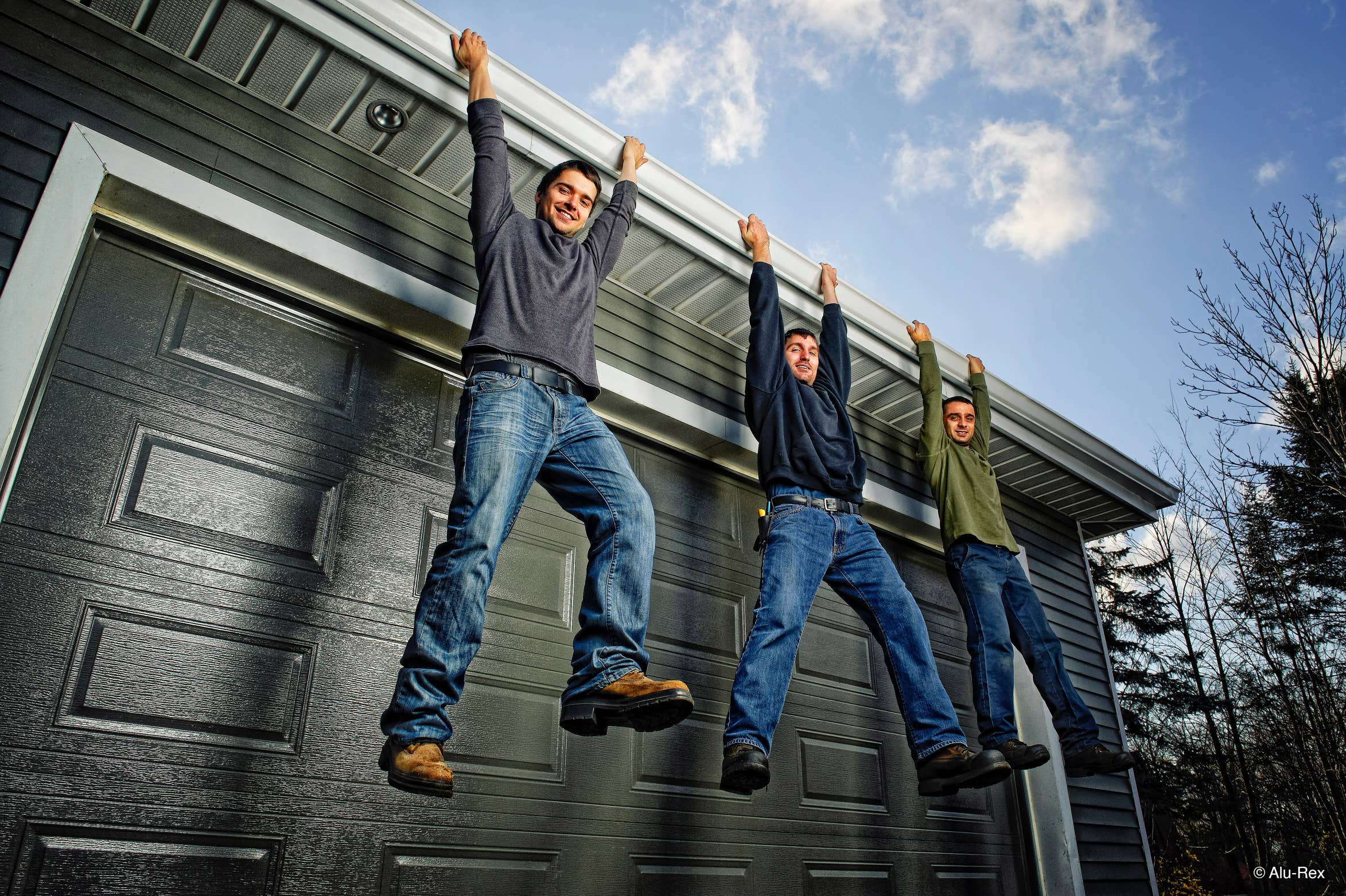 Three men hanging from a gutter